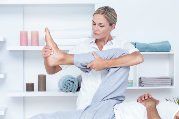 Fisioterapeuta fazendo massagem com as pernas para o paciente