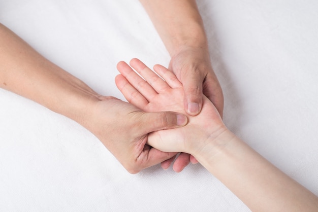 Fisioterapeuta fazendo massagem na mão no consultório médico