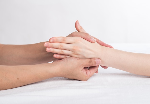 Foto fisioterapeuta fazendo massagem na mão no consultório médico