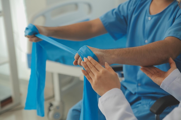 Foto fisioterapeuta guiando paciente com banda de resistência