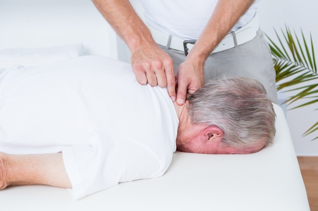 Fisioterapeuta haciendo masaje de cuello a su paciente