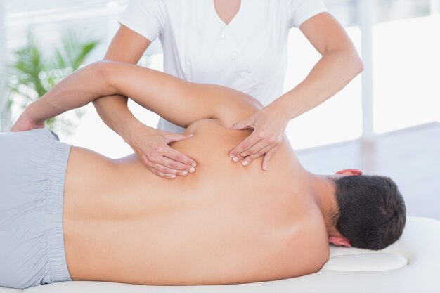 Fisioterapeuta haciendo masaje de espalda a su paciente