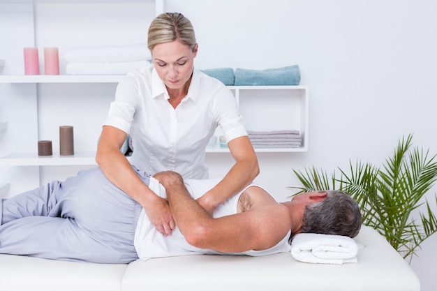 Fisioterapeuta haciendo masaje de hombros a su paciente