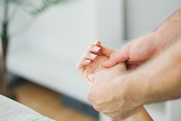 Fisioterapeuta masajeando la mano de un paciente