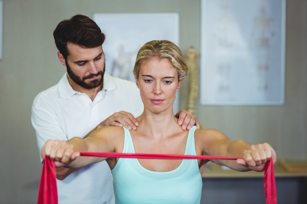 Fisioterapeuta masculino dando massagem nos ombros para paciente do sexo feminino
