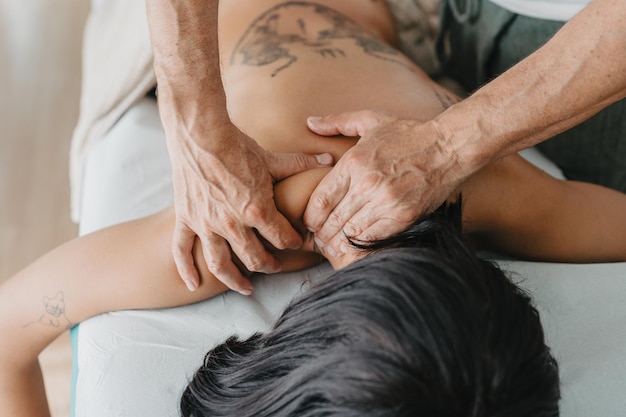Fisioterapeuta massageando a parte inferior do pescoço de uma mulher