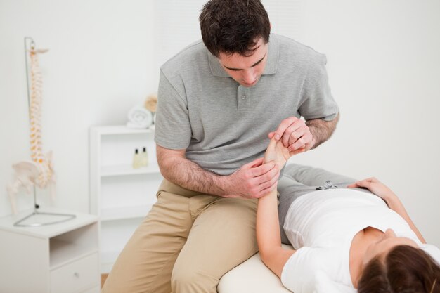 Fisioterapeuta mirando la muñeca de un paciente