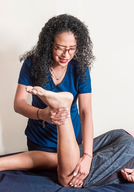 Fisioterapeuta con paciente realizando flexión de rodilla Fisioterapeuta realizando flexión de rodilla fisioterapia concepto de rehabilitación de rodilla