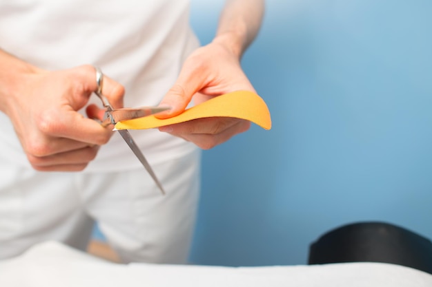 Fisioterapeuta prepara y corta kinesio taping