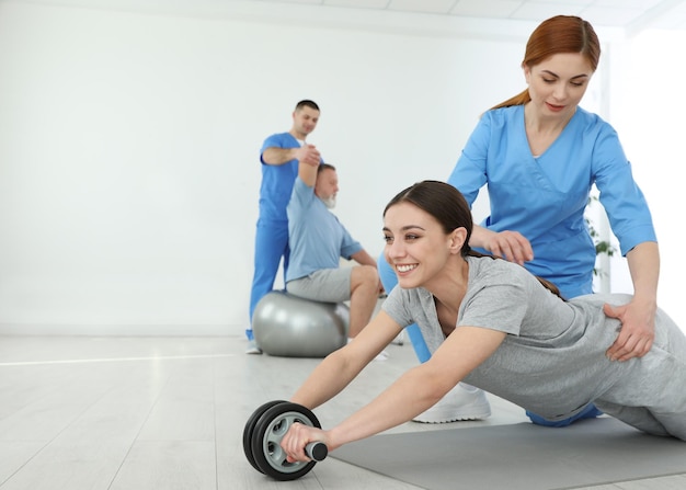 Fisioterapeuta profesional que trabaja con una paciente en un centro de rehabilitación Espacio para texto