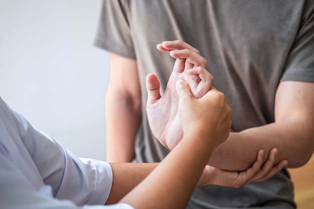 Fisioterapeuta que trata o braço ferido de um homem