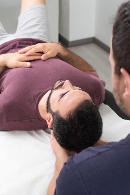 Foto fisioterapeuta realizando un masaje en el cuello de un paciente