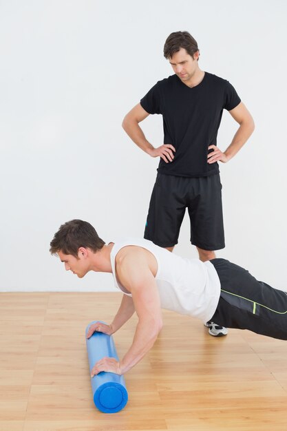 Fisioterapeuta viendo joven hacer flexiones