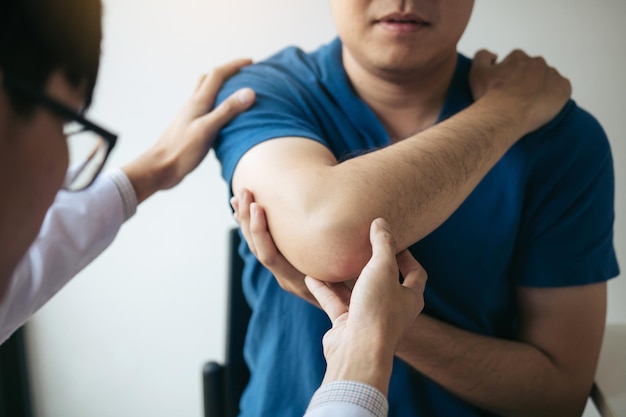 Los fisioterapeutas están revisando los codos de los pacientes en la sala de oficinas de la clínica.
