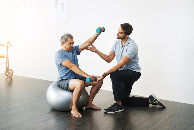 Foto fisioterapia con pesas y ayuda con el médico y el anciano para el entrenamiento de rehabilitación o el estiramiento bienestar de la salud y curación con el paciente y el fisioterapeuta para consultar los músculos o el equilibrio