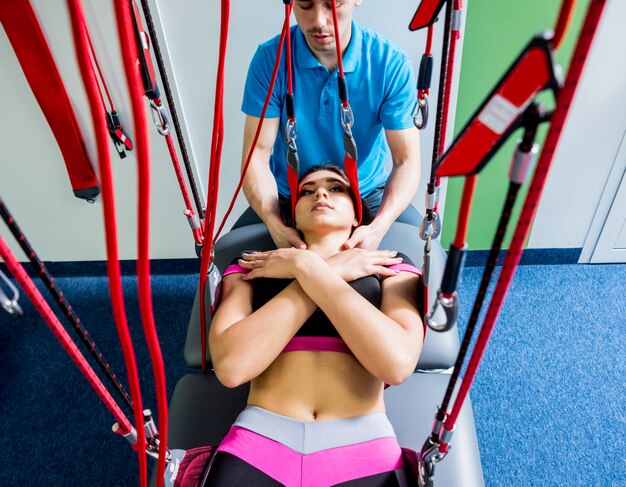 Fisioterapia. Terapia de treinamento em suspensão. Jovem mulher fazendo tração fitness