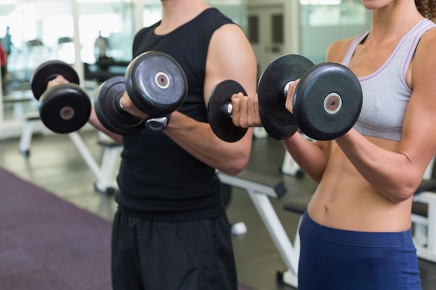 Fit casal levantando halteres juntos