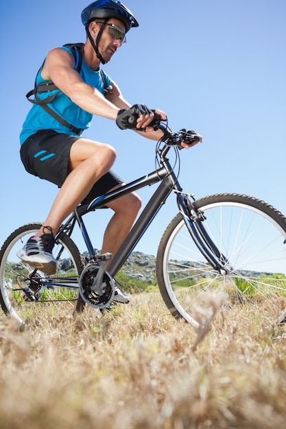 Fit ciclista andando no campo