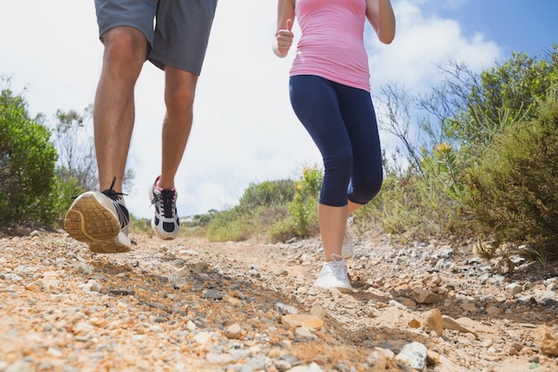 Fit couple correndo pela trilha da montanha