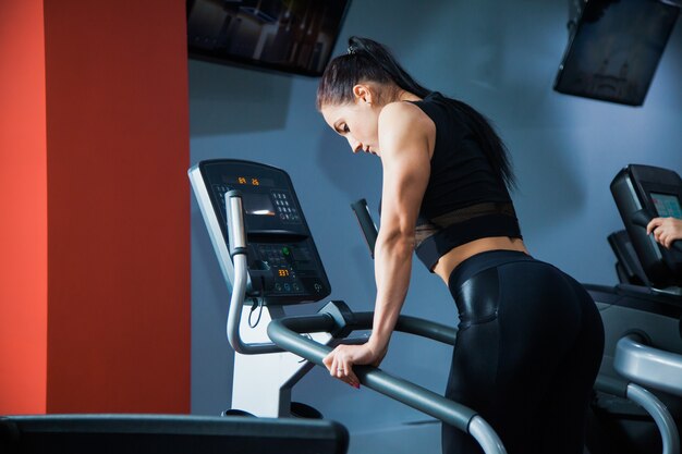 Fit Frau auf Cardio-Stepper-Maschine im Fitnessstudio