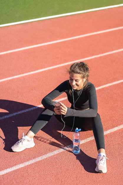 Fit Frau in Sportbekleidung nach dem Training oder Laufen ruhen