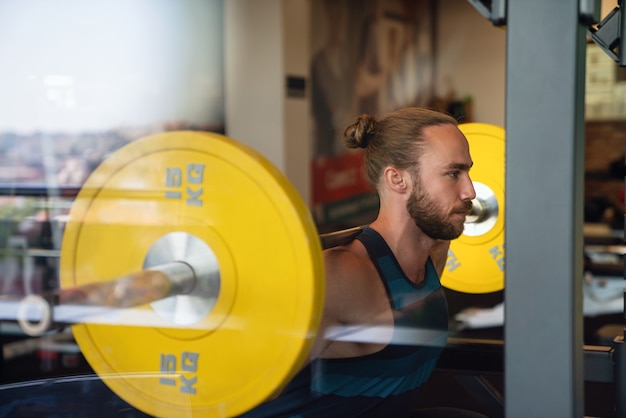 Fit gut aussehender Mann, der im Fitnessstudio auf einer Maschine trainiert