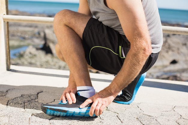 Fit hombre agarrando su tobillo lesionado