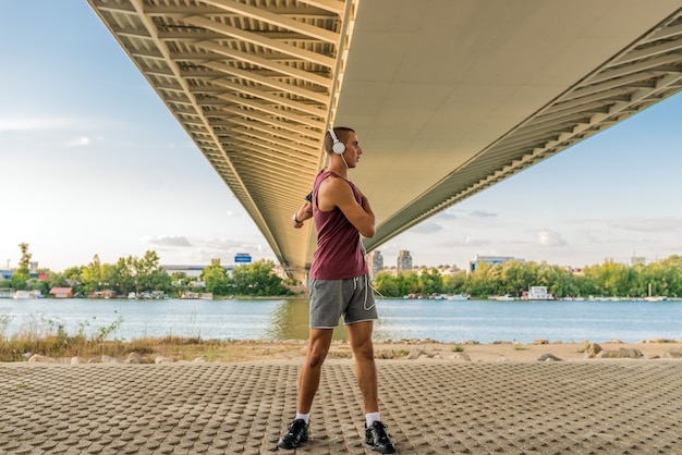 Fit homem exercitar sob a ponte, levando uma vida saudável