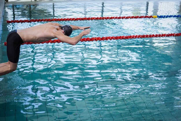 Fit homem mergulho na água na piscina