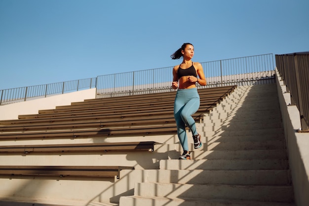 Foto fit junge frau in sportkleidung macht yoga fitness-übungen auf der straße sport aktives leben