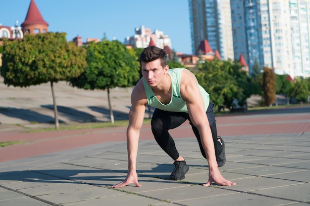 Fit macho em agasalho e tênis na paisagem urbana