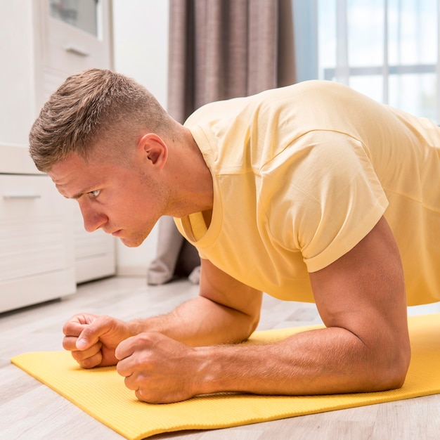 Foto fit mann, der ein training zu hause macht