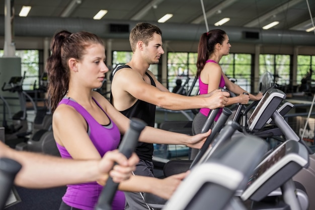 Fit Menschen auf Ellipsentrainer im Fitnessstudio