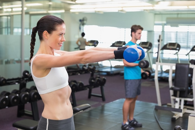 Fit morena levantando dumbbell azul