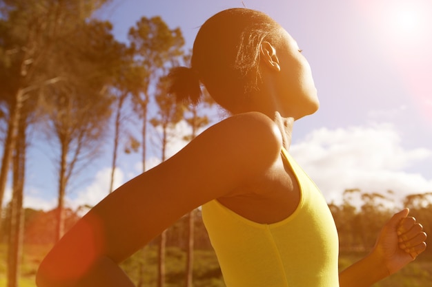 Fit mujer africana corriendo al aire libre en un día soleado