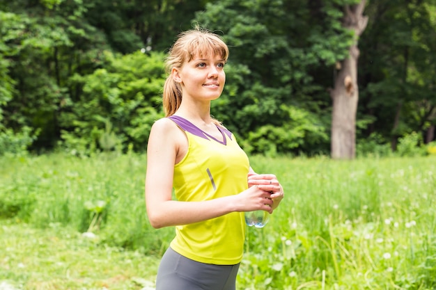 Fit mujer afuera sosteniendo una botella de agua