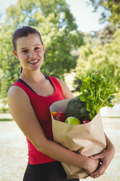Fit mujer con bolsa de comestibles saludables