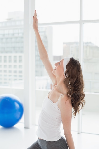 Fit mujer estirando la mano en el gimnasio