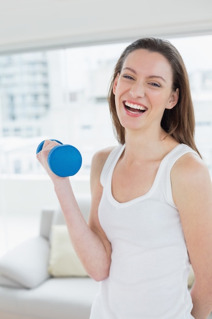 Fit mujer haciendo ejercicio con pesas en el gimnasio