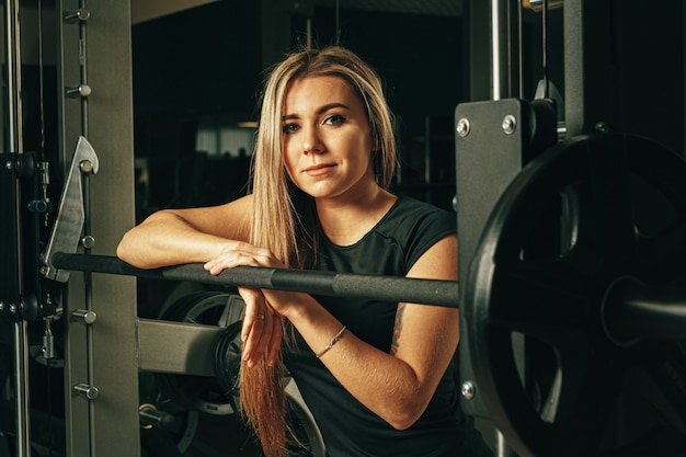 Fit mujer haciendo sentadillas en una máquina Smith en el gimnasio