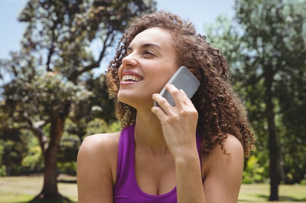 Fit mujer en el teléfono en el parque