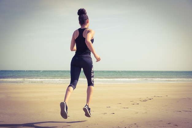 Fit mujer trotando en la arena