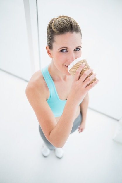 Fit mulher em roupas esportivas tomando café