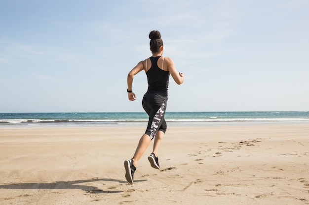 Fit mulher jogging na areia