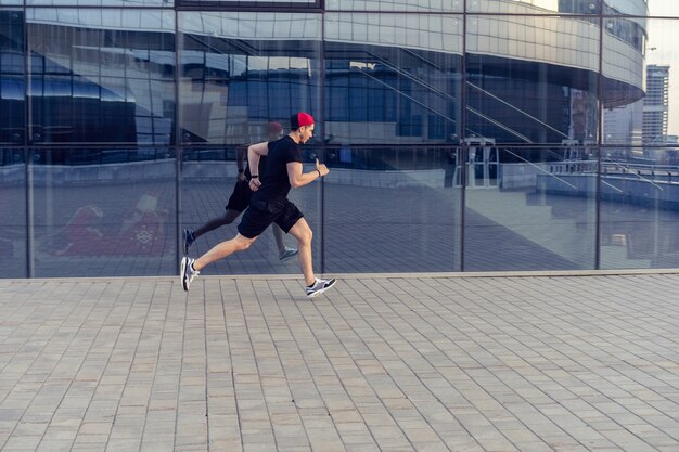 Fit Sportler laufen im Freien, um gesund zu bleiben. Sportlicher junger Mann läuft