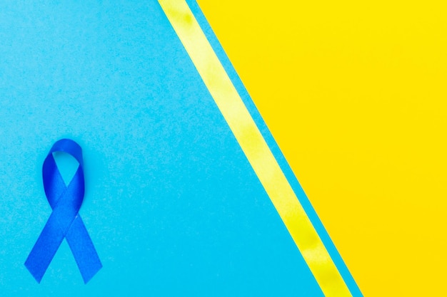 Foto fita azul escuro conscientização para o conceito do dia da aids fundo amarelo-azul