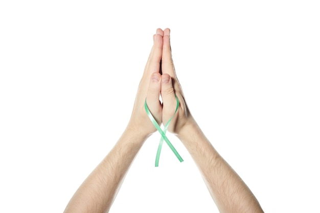 Fita da consciência verde na mão. símbolo de saúde mental, doença de lyme ou doença renal. fundo branco isolado.