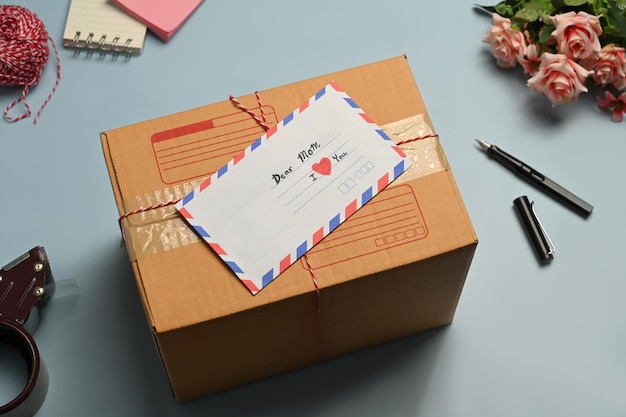 Foto fita de envelope de correspondência de caixa de papelão e cabos de corda em fundo azul