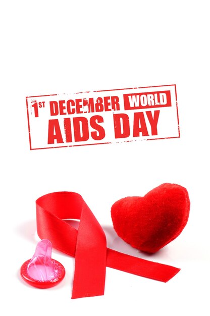 Foto fita de sida, preservativo e coração em fundo branco.