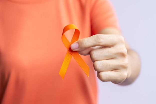 Foto fita laranja para leucemia dia mundial do câncer de rim esclerose múltipla crps mês de conscientização de autolesão cuidados de saúde e conceito de dia do câncer de palavra